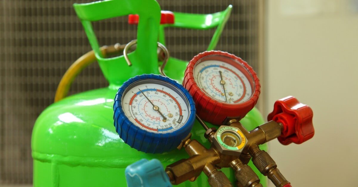 HVAC gauges resting on a tank of refrigerant